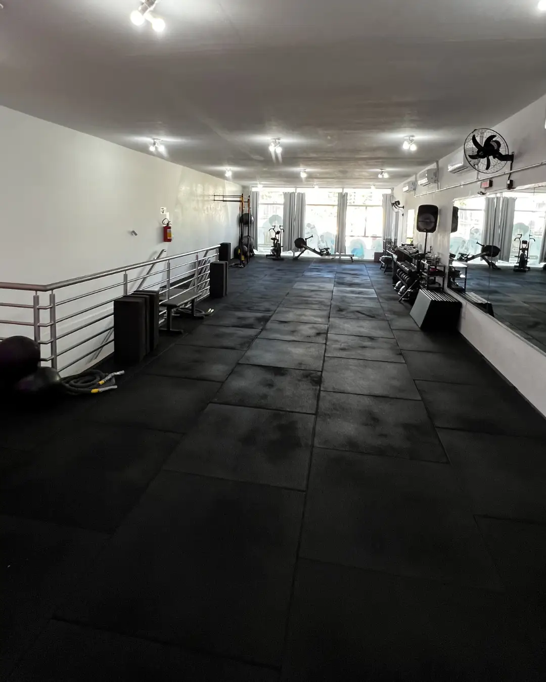 Área ampla de treino funcional com espelho e equipamentos